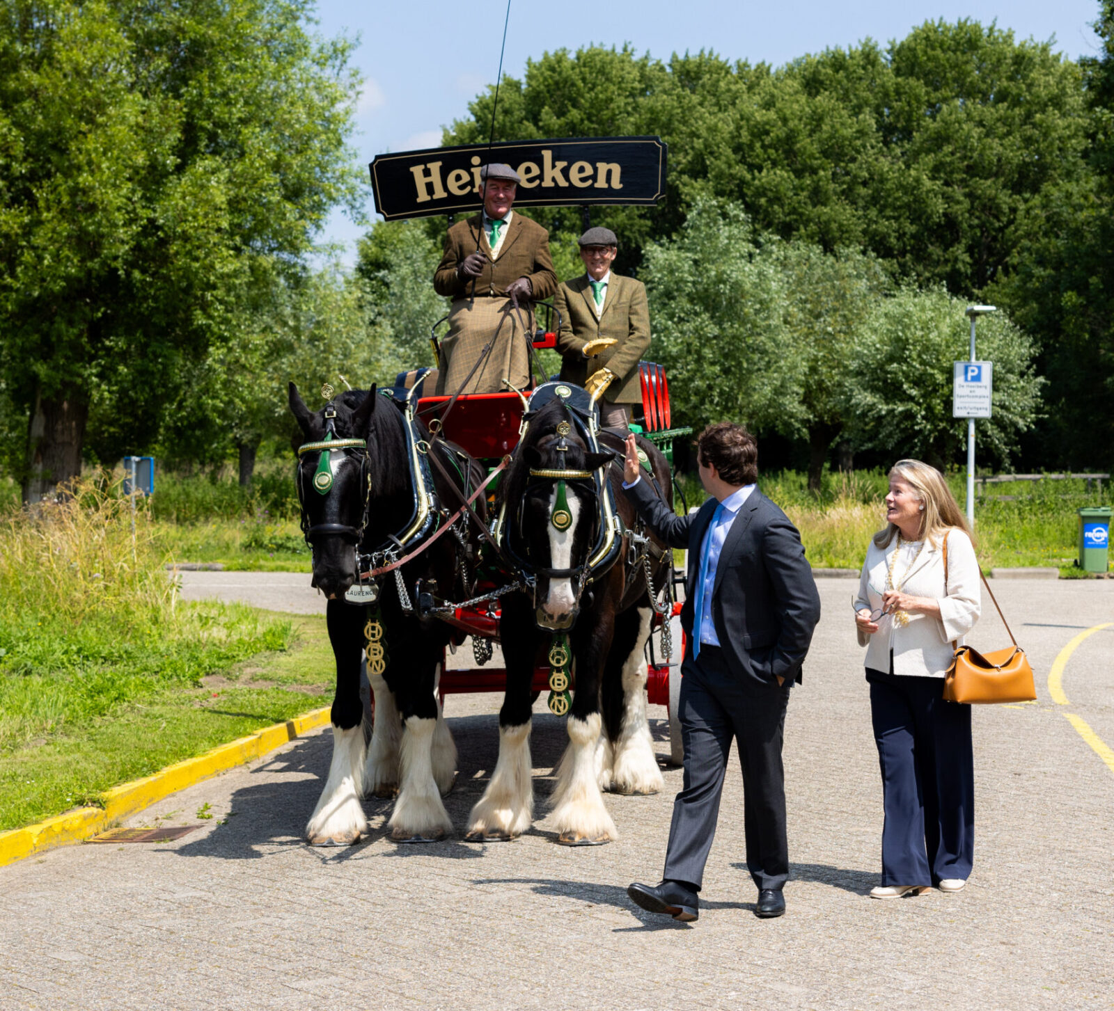 Mrs Heineken and her son walking past the Shire horses and waving.